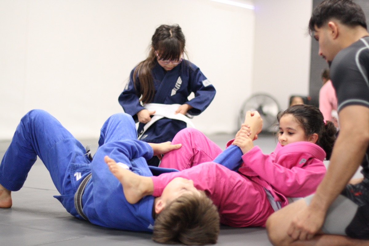 Kids drilling Jiu Jitsu in gis on the mats